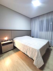 Apartamento 3 Suítes - Itapema tesisinde bir odada yatak veya yataklar