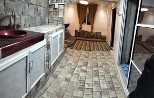 ein Badezimmer mit einem Waschbecken und einer Steinmauer in der Unterkunft نزل الريف التراثيه in Al ‘Aqar