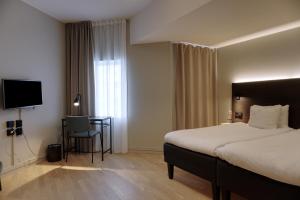 Un pat sau paturi într-o cameră la First Hotel Jönköping