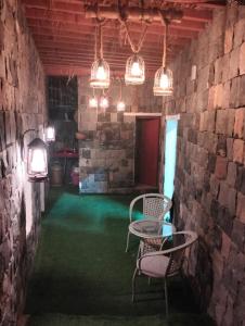 um quarto com uma mesa, cadeiras e luzes em نزل الريف التراثيه em Al ‘Aqar