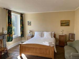 Un dormitorio con una cama y un sofá y una ventana. en Grammelot, en Beauraing