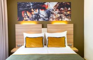 a bedroom with a bed with yellow pillows at Leonardo Boutique Hotel Salzburg Gablerbräu in Salzburg