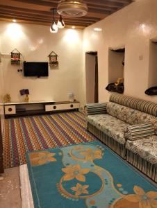 a living room with a couch and a flat screen tv at نزل الريف التراثيه in Al ‘Aqar