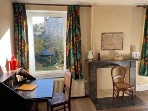 salon ze stołem, krzesłami i kominkiem w obiekcie Grammelot w mieście Beauraing