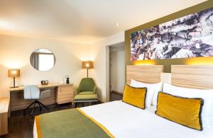 a hotel room with a bed and a desk at Leonardo Boutique Hotel Salzburg Gablerbräu in Salzburg