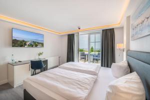 a hotel room with a bed and a desk at Hotel Königslinie in Sassnitz