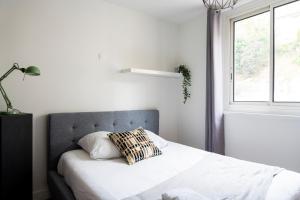 1 dormitorio con cama con almohada y ventana en Charmant appartement 4 personnes en centre-ville, en Caen