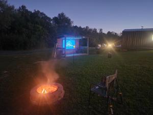 a fire pit in a field at night with a building at Chigger Hill RV Park in Hatfield