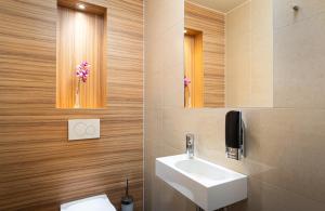 a bathroom with a sink and a toilet and a mirror at Leonardo Boutique Hotel Salzburg Gablerbräu in Salzburg