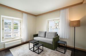 a living room with a couch and two windows at Leonardo Boutique Hotel Salzburg Gablerbräu in Salzburg