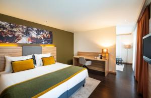 a hotel room with a bed and a desk at Leonardo Boutique Hotel Salzburg Gablerbräu in Salzburg