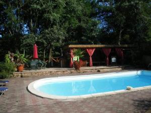 una piscina en un patio con cenador en Les sources, en Gourbera