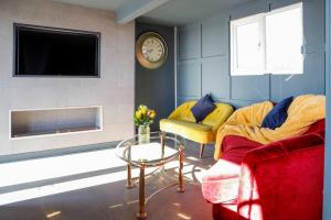 Modern 2 Bed 2 Bath - Plymouth في بلايموث: غرفة معيشة فيها كرسيين وطاولة وساعة