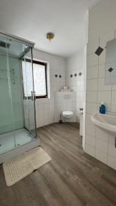 a bathroom with a shower and a toilet and a sink at Highway Ferienwohnung in Preußisch Oldendorf