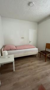 a bedroom with a bed and a table and a chair at Highway Ferienwohnung in Preußisch Oldendorf