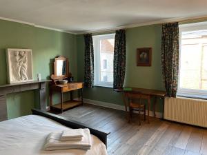 sypialnia z łóżkiem i biurkiem oraz 2 oknami w obiekcie Grammelot w mieście Beauraing