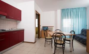 a kitchen and dining room with a table and chairs at Residence Villa Azzurra in Rimini