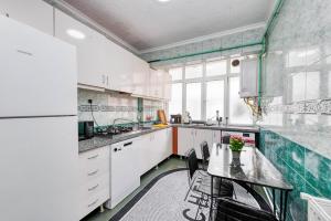 a kitchen with white cabinets and a table with chairs at Nil Denis Palace in Istanbul