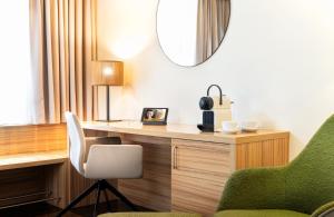 a room with a desk with a chair and a mirror at Leonardo Boutique Hotel Salzburg Gablerbräu in Salzburg