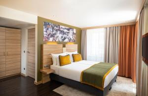 a bedroom with a large bed with yellow pillows at Leonardo Boutique Hotel Salzburg Gablerbräu in Salzburg