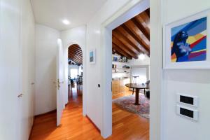 a hallway with white walls and a dining room with a table at Mini Suite Deluxe Isola di Mezzo in Treviso