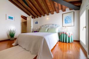 a bedroom with a white bed and a wooden floor at Mini Suite Deluxe Isola di Mezzo in Treviso