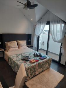 een slaapkamer met een bed en een plafondventilator bij Casa Pico Musica in Funchal