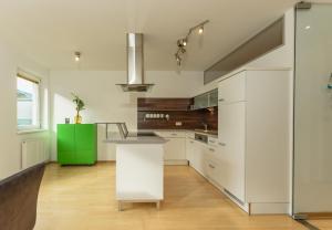 kuchnia z białymi szafkami i zieloną wyspą w obiekcie Appartement Lilie by Schladming-Appartements w Schladming
