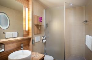 a bathroom with a sink and a shower at Leonardo Boutique Hotel Salzburg Gablerbräu in Salzburg