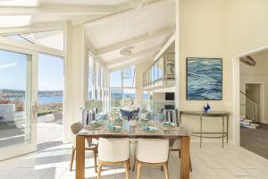 una sala da pranzo con tavolo, sedie e finestre di 3911 Point Lobos View home a Carmel