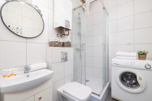 a bathroom with a toilet sink and a washing machine at Cozy Apartment Aleja Kijowska in Cracow by Renters in Krakow