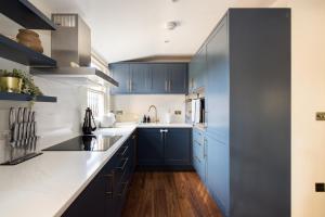 eine Küche mit blauen Schränken und weißen Arbeitsplatten in der Unterkunft The Marylebone Escape - Lovely 1BDR Flat in London
