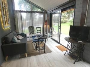 a living room with a television and a table and chairs at Gîte de linxe in Linxe