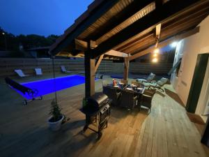 an outdoor patio with a grill and a pool at Gîte de linxe in Linxe