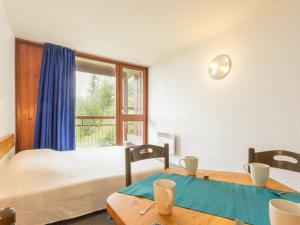 a bedroom with a bed and two tables and a window at Studio Les Arcs 1800, 1 pièce, 5 personnes - FR-1-346-508 in Arc 2000