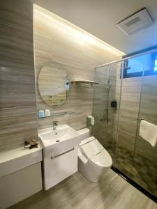 a bathroom with a sink and a toilet and a mirror at Ramble Travel Homestay in Guanshan