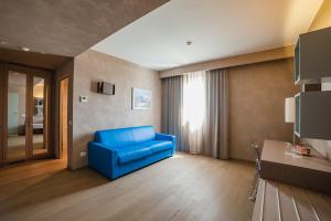 un soggiorno con divano blu in una camera di Cala Ponte Hotel a Polignano a Mare