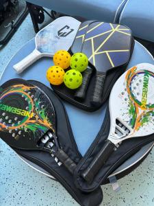 a table with tennis rackets and balls on it at Naples Dream at WTC with Heated Pool SPA Sauna 7 bicycles and 3 mls to beach in Naples