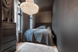 een slaapkamer met een bed en een kroonluchter bij Casa Deluxe in Bergen