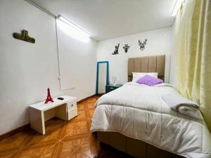 a bedroom with a large bed and a white table at Hermoso apartamento acogedor-cocina wi-fi 500MB in Bogotá