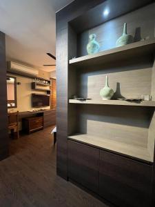 a living room with shelves with vases on them at Guest Studio/Suite Condominum Near Batu Caves in Batu Caves