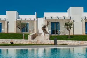 a villa with a swimming pool in front of a house at Cala Ponte Hotel in Polignano a Mare