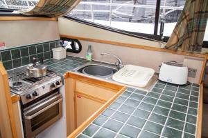 a kitchen with a sink and a stove at Caley Cruisers in Inverness