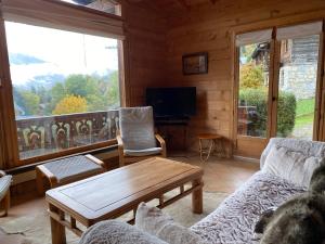 sala de estar con sofá y mesa en Les Oiseaux Bleus, en Morillon