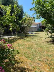 a yard with grass and trees and a house at Apartment 20mns from Paris in La Ville-du-Bois