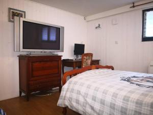 - une chambre avec une télévision à écran plat et un lit dans l'établissement Rooms near Paris (20mn to Paris), à La Ville-du-Bois