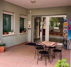 Residence Villa Azzurra في ريميني: فناء مع طاولة وكراسي في غرفة