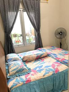 - un lit dans une chambre avec fenêtre dans l'établissement Homestay Lavender C6 Palembang, à Palembang