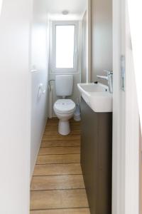 uma casa de banho com um WC, um lavatório e uma janela em Camping Sabbiadoro em Lignano Sabbiadoro