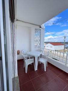 een witte tafel en stoelen op een balkon met uitzicht bij BLife Faro Beach Hostel in Faro